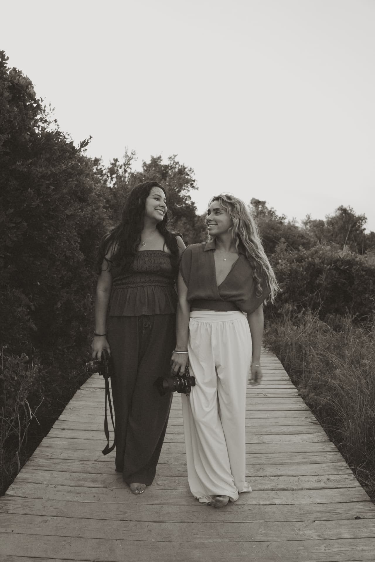 Two photographers walking a coastal boardwalk