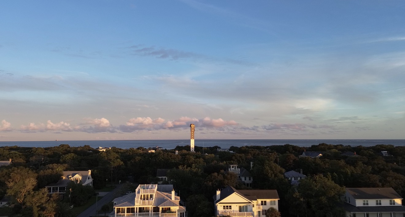 Aerial coastal view with lighthouse at sunset
